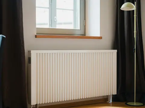Vitt element under ett fönster i ett ljust rum